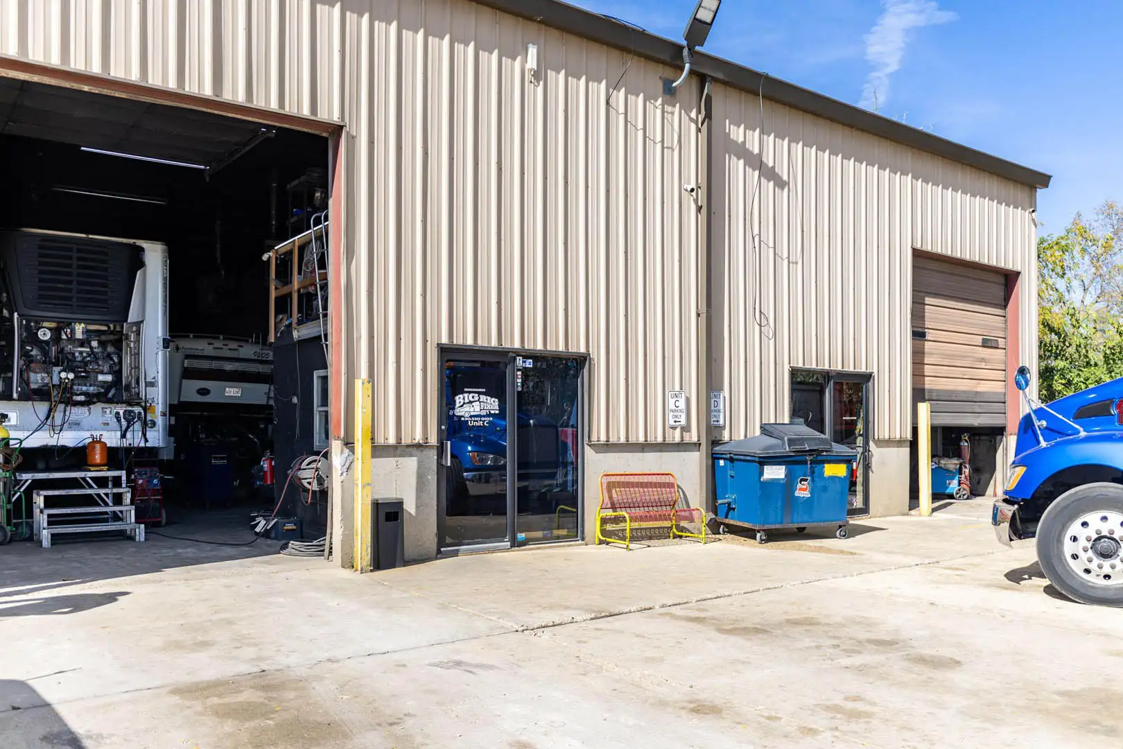 The Big Rig Fixer shop in Carol Stream, IL, with a reefer trailer in the open bay and the Unit C entrance