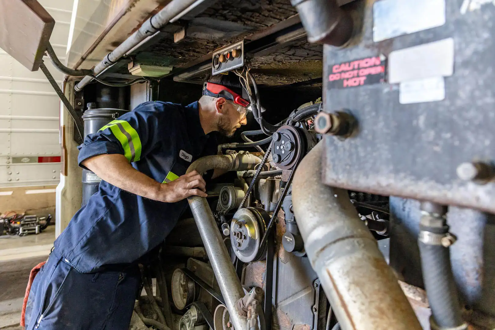Technician inspecting a transit bus