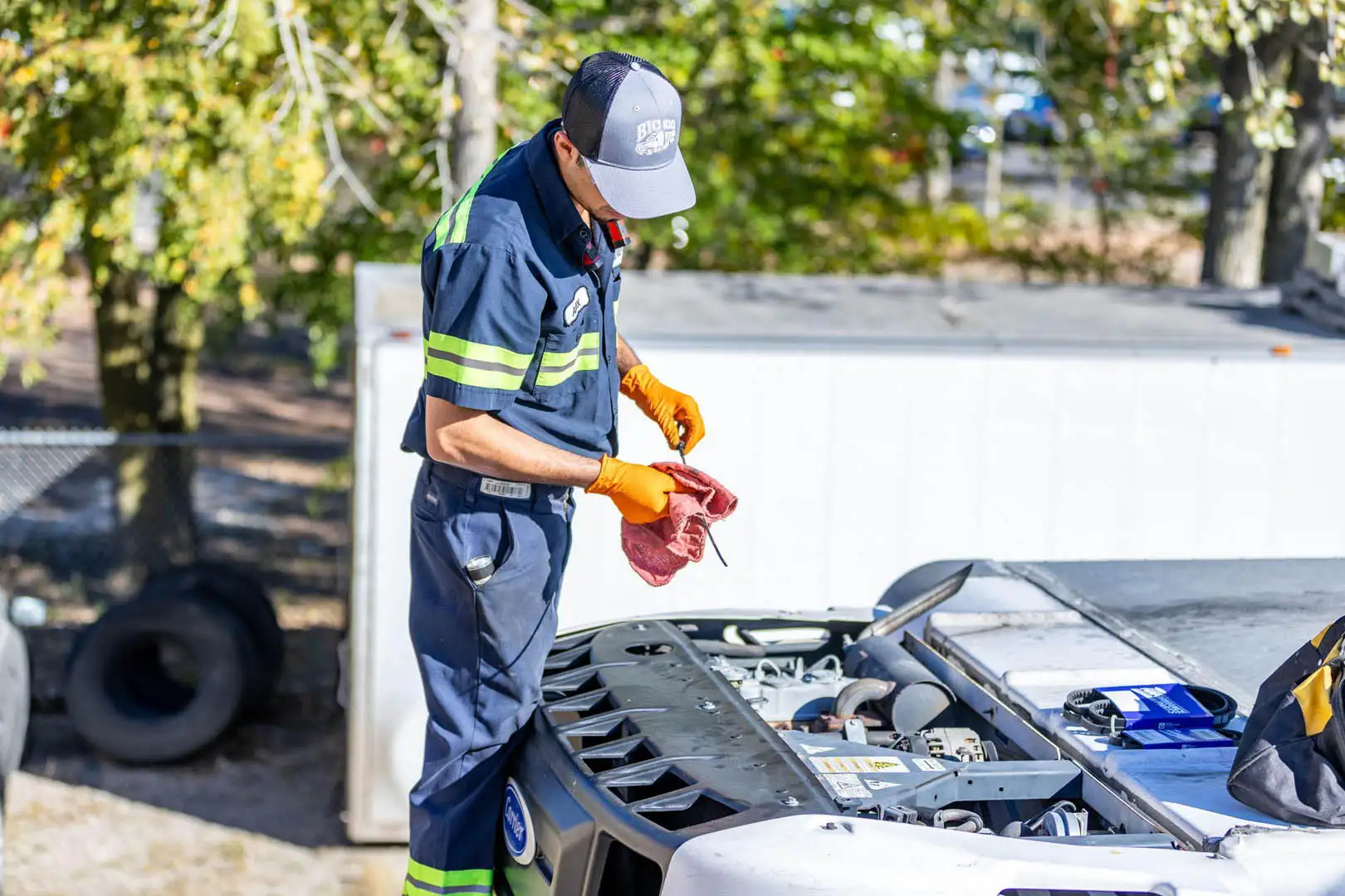 Technician checking reefer oil dipstick