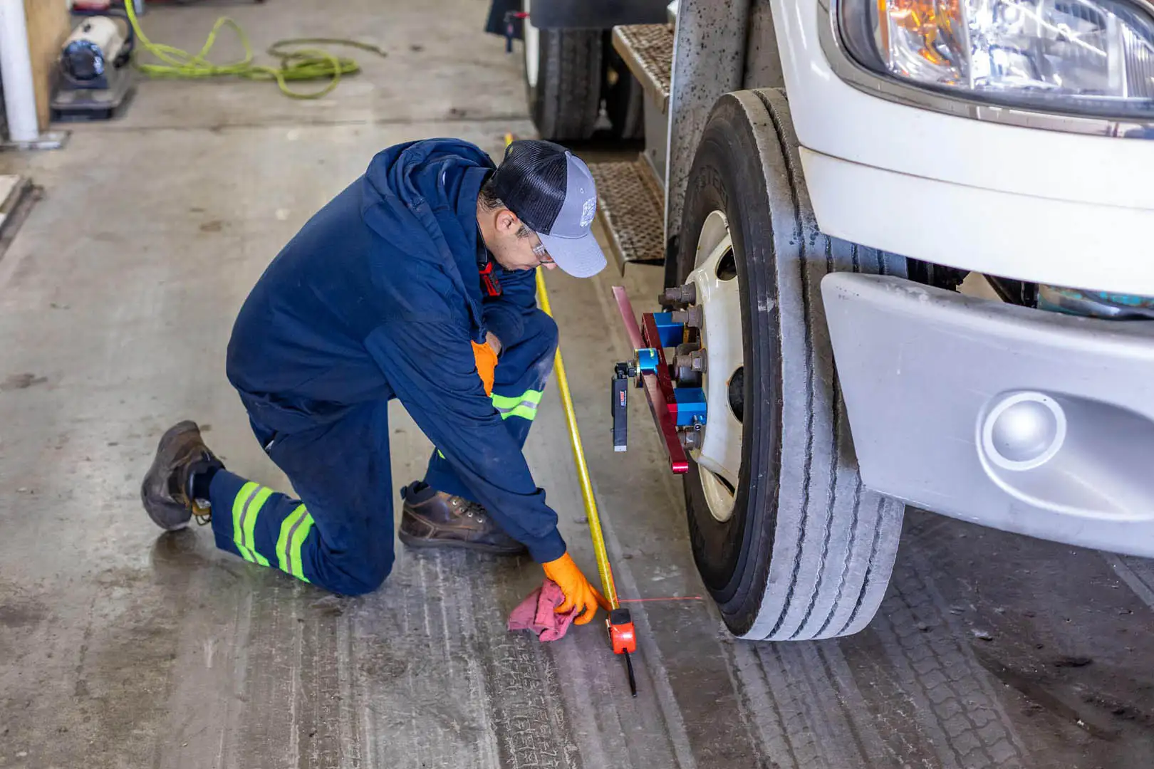 Technician aligning front axle of a heavy-duty truck