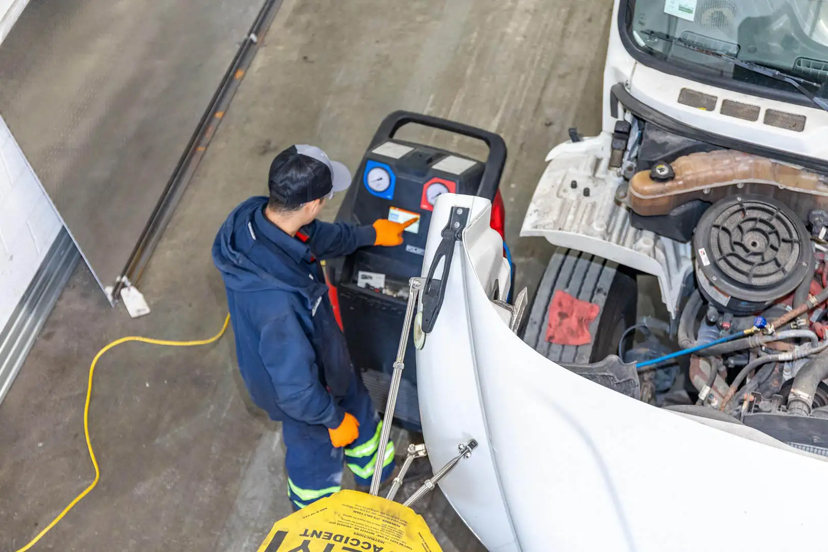 Technician performing A/C leak test with UV light