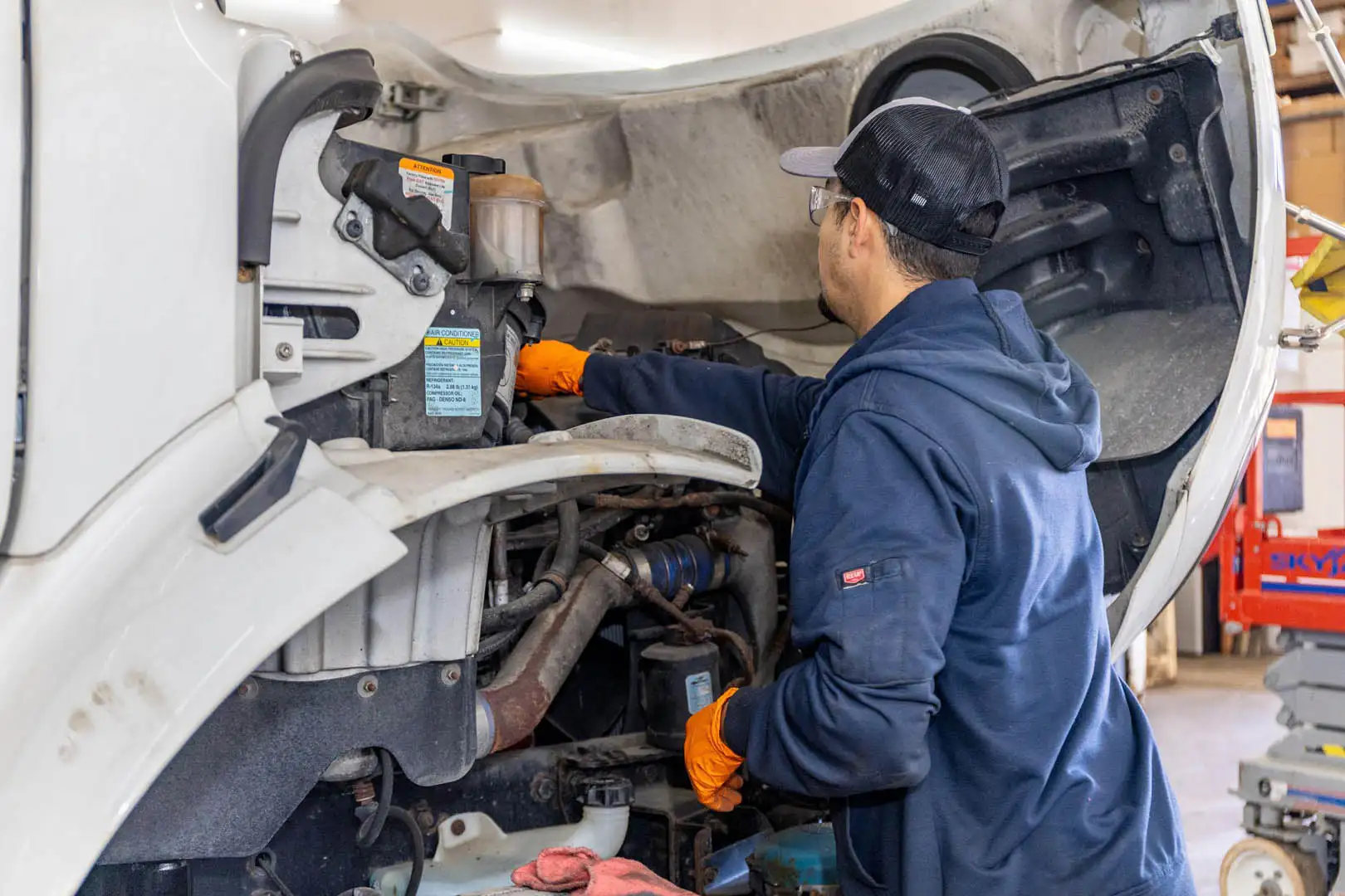Technician performing oil change on semi truck